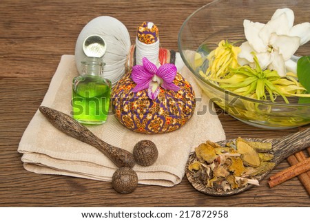 Thai spa massage setting with thai  herbal compress balls, essential oil bottle, towel,ylang-ylang flower