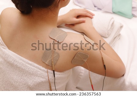 Asian woman is doing massage of electrical stimulation ( TENs ) for the back