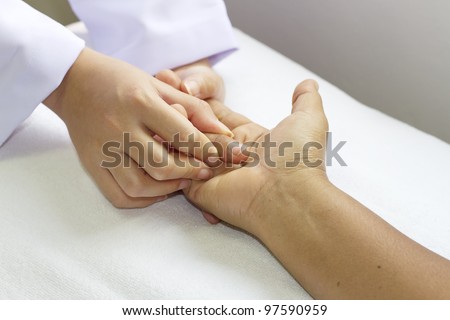 physical therapist checks range of motion for finger and hand