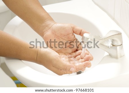 Washing of hands  under the crane with water