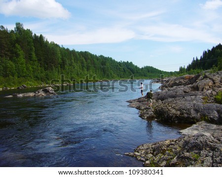Beautiful landscape view of river in a green forest. Fishing man