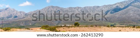 SWARTBERG PASS, SOUTH AFRICA - JANUARY 2, 2015: The historic Swartberg (Black Mountain) Pass is seen in the background with Kobus se Gat in the foreground. The pass is a declared national monument.