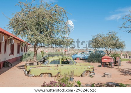 FISH RIVER CANYON, NAMIBIA - JUNE 17, 2011: Old rusted cars  and a tractor used as a display in a garden  at a lodge near the Fish River Canyon