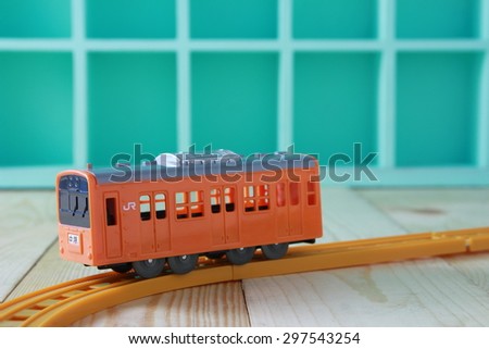 Orange toy train on wooden background