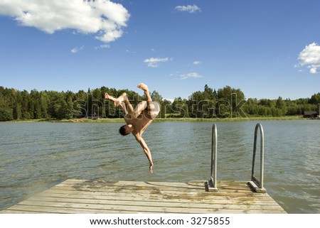 Man jumping from the pier to the sea
