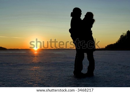 Silhouette of a couple hugging on ice