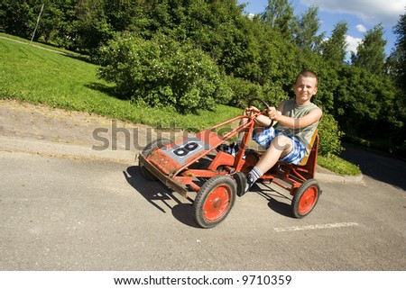 Boy driving a pedal car