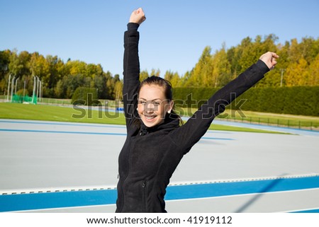 Woman hands in the air on athletics field