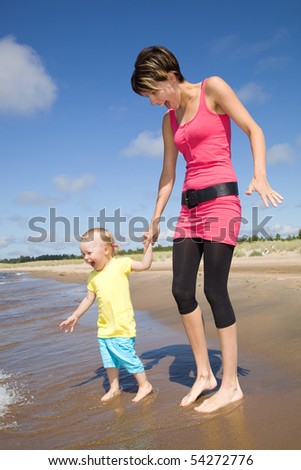 Mother running with her daughter on a beach