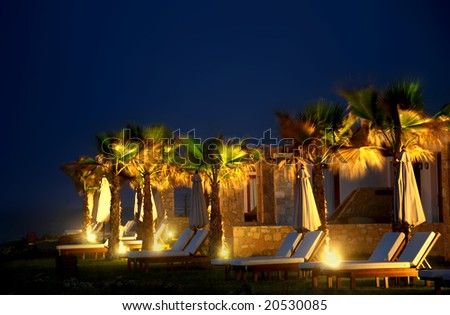 Chaise-longs in front of a greek hotel, night view