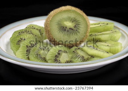 Kiwi fruit slices on saucer isolated on  black background