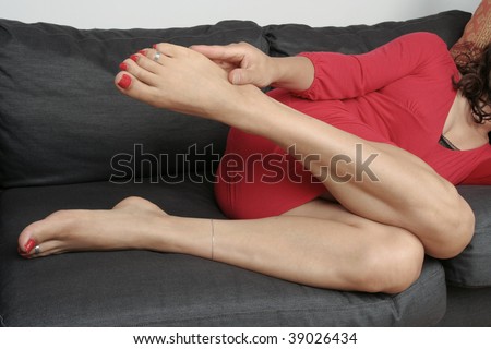 Beautiful woman  legs with  dress massaging aching feet