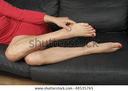 Beautiful woman  legs  massaging aching feet lying