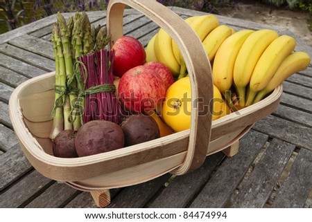 Mixed bunch of fresh vegetables and fruit produce in basket outdoors