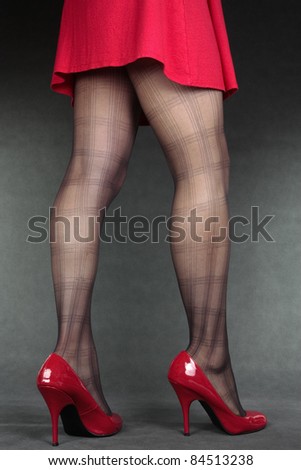 Woman legs wearing tights and red heels dress