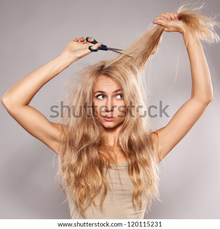 Young Woman Looking At Split Ends. Damaged Long Hair