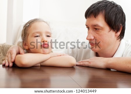 Father comforts a sad girl. Problems in the family