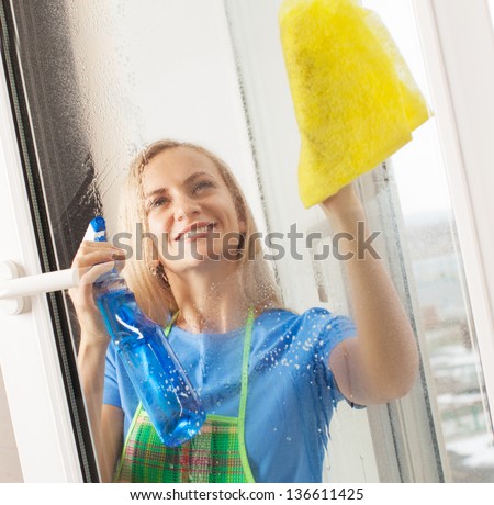 Woman washing window. Housewife cleaning window at home. Housework