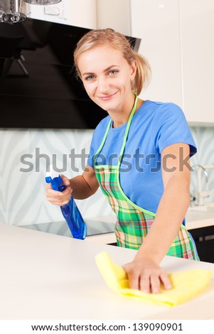 Woman cleaning kitchen. Young woman washing house
