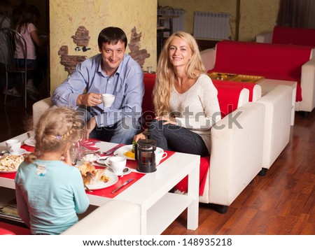 Happy family eating in restaurant. Mother, Father and child in cafe