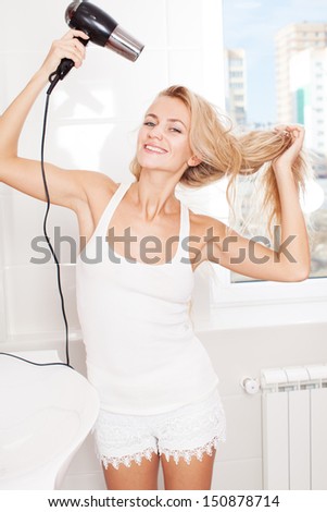 Woman dry hair hairdryer at bathroom. Female with dryer at home