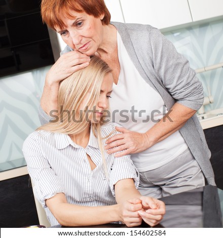 Mother soothes sad daughter. Mature woman calm young woman