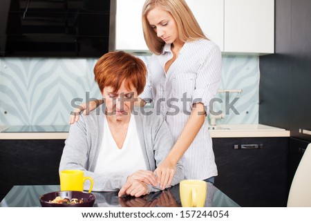 Daughter soothes sad mother. Young woman calm mature woman