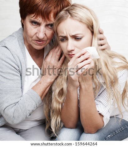 Mother soothes crying daughter. Mature woman calm young sad woman