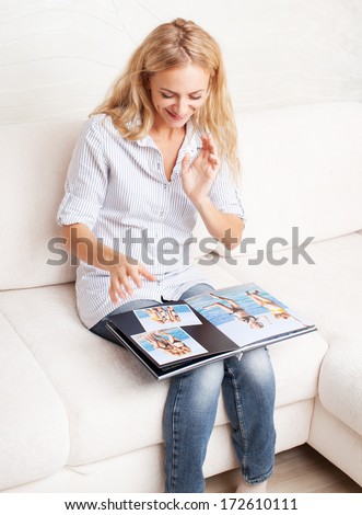 Young woman looking photo book. Female with photography album