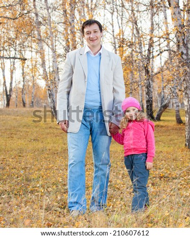 Father playing with daughter at autumn. Family outdoors