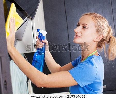 Woman cleaning kitchen. Young woman washing kitchen hood