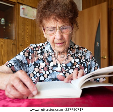 Old woman. Elderly female at home reading Book