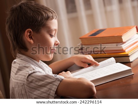 Boy reading book at home. Child education