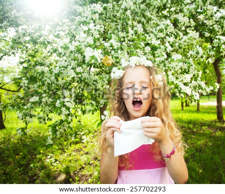 Sneezing girl. Child with a handkerchief. Allergy