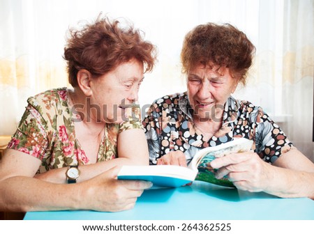 Two seniors. Old woman reading book. Friendship elderly