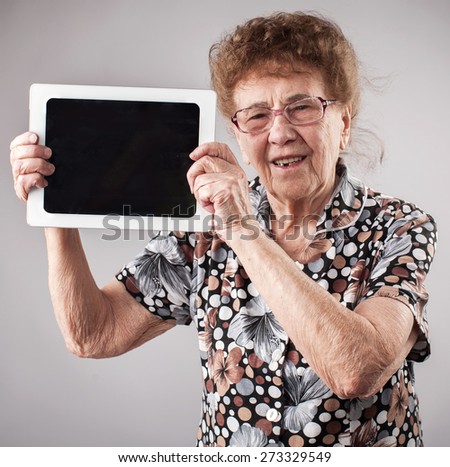 Old woman holding a tablet in the hands of. Seniors with tablen pc