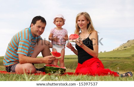 Happiness family on picnic eats a water-melon