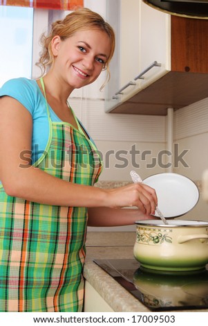 Woman prepares soup on kitchen 2