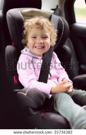 Happy girl in an automobile carseat