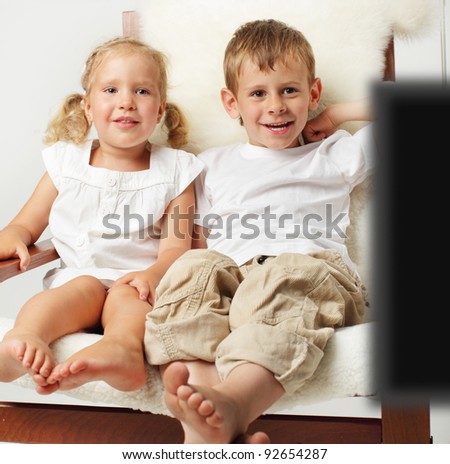 Brother and sister watching TV at home
