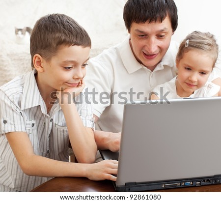 Happy family with laptop. Father with children play in the computer