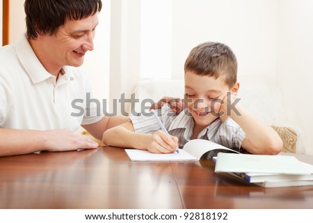 Father helping son do homework. Parent helps his child