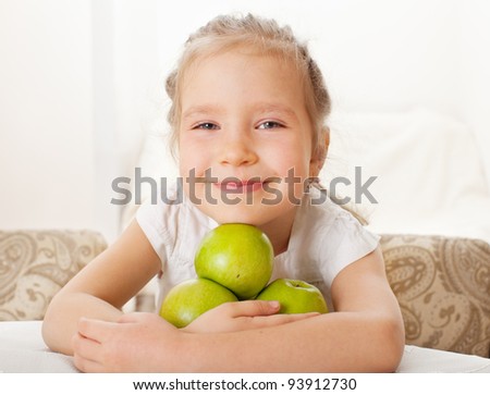Child with apples. Little girl at home in the kitchen eating fruit