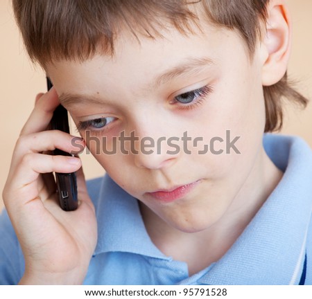 Child, talking on the phone. Sad boy talking on mobile phone