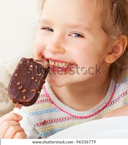Child eating ice cream. Little girl at home