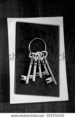 Old keys group on black and white stone background, high contrast black and white photo