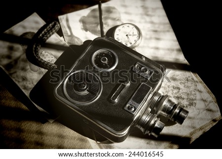 Abstract vintage textured image of an old retro 8mm video camera and photos