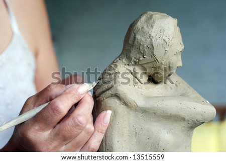 Close up to Sculptor\'s hand and her sculpture while she is working on it