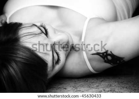 Woman lying on floor ,focus on her eye lashes ,black and white studio shot