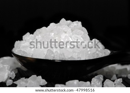 Sea Salt on black spoon, on black background